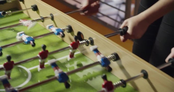 group of friends playing table football. indoor in modern industrial house. caucasian. 4k handheld slow motion detail video shot