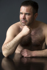 Obraz premium man sitting at table with naked upper body