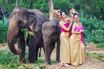 Beautiful Asian Woman wears thai dress with her elephant	