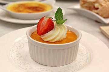 Crème Brulee served with cream, strawberry and mint leaf 