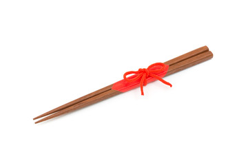 Japanese wooden chopsticks wrapped in red paper and red rope on white background.