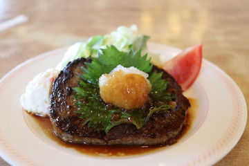 Japanese style hamburger steak, grated white radish on top of it 