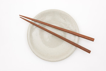 Traditional Japanese wooden chopstick on white ceramic plate