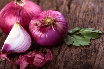 Close up of the  sliced red onion and whole bulb onion on a wooden background © Cozine