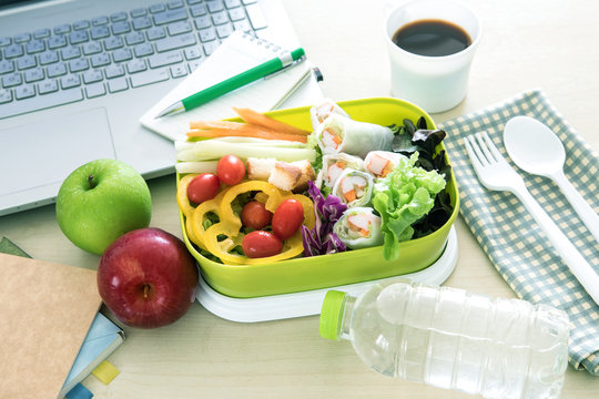 Close up the green Lunch box on work place of working desk ,Healthy eating clean food habits for diet and health care concept