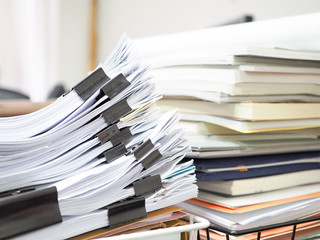 Many documents are on the desk.