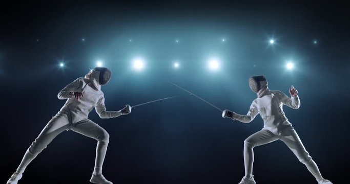 4K video in slow motion of two female fencing athletes. The action takes place on professional sports arena with spectators and lense-flares. Women wear unbranded sports clothes. Arena is made in 3D.