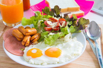  Breakfast with fried eggs, bacon, sausages, toasts and fresh salad