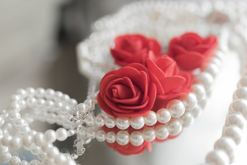 Pearl necklace and red roses
