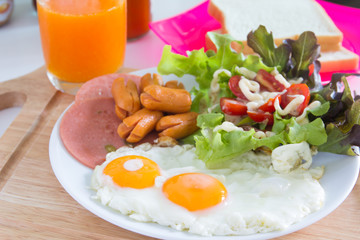  Breakfast with fried eggs, bacon, sausages, toasts and fresh salad