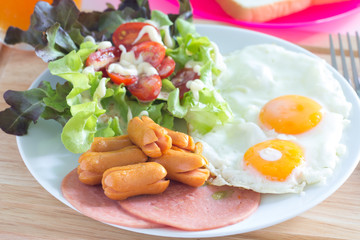  Breakfast with fried eggs, bacon, sausages, toasts and fresh salad