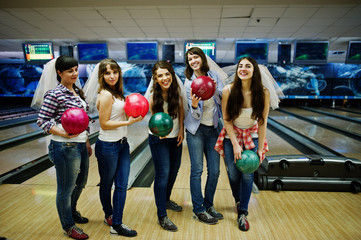 Group of six girls wit bowling balls at hen party on bowling club.