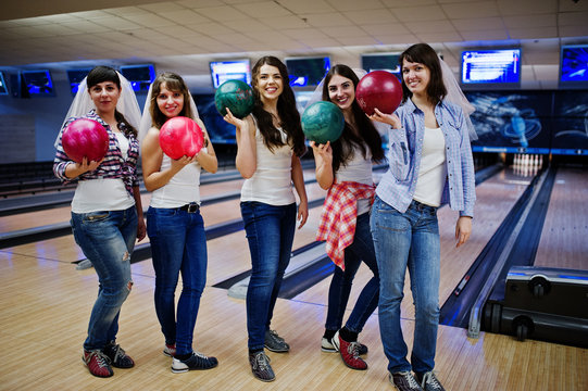 Group of six girls wit bowling balls at hen party on bowling club.