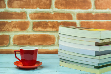 Books, coffee mug,  Red brick background