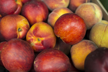 Fototapeta na wymiar Fresh organic peaches. Heap of fresh ripe peaches at a street market. 
