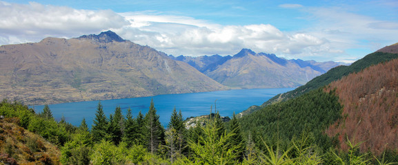 Lake surrounded by tall mountains and pine trees