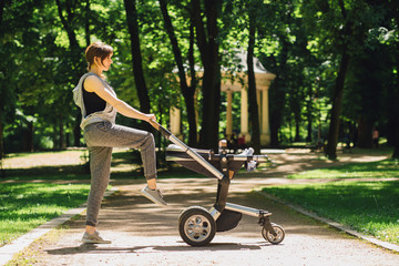 Series of exercises with a stroller - young gorgeous mother with baby stroller workout in the park. Sport, maternity, healthy lifestyle concept