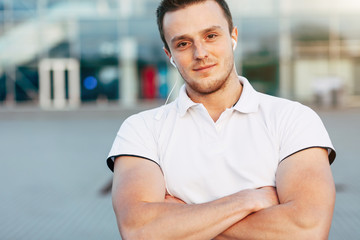 Portrait of Young Muscular Man in White T-shirt Posing on Airport Parking