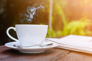 coffee cup clock and news paper on old wooden table nature background