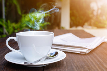 coffee cup clock and news paper on old wooden table nature background