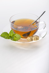 Tee mit Minze und Rohrzucker in der Glas-Teetasse