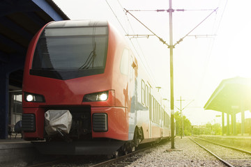 Naklejka premium Modern high-speed train on a clear day with motion blur. Beautiful railway station with modern red commuter train.