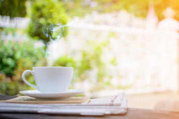 coffee cup clock and news paper on old wooden table nature background