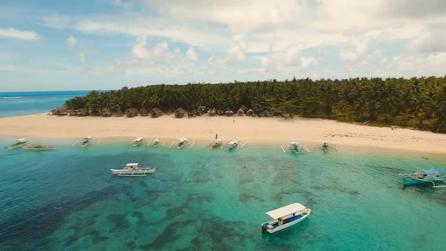 Aerial view of beautiful tropical island Daco with white sand beach. View of a nice tropical beach from the air. Beautiful sky, sea, resort. Seascape: Ocean and beautiful beach paradise. Philippines