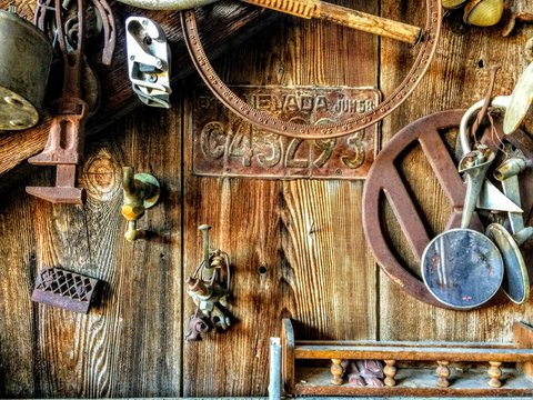 Collectible rusty Antiques on wall of old barn in historic ghost mining town in Nevada 