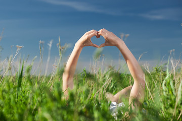 Woman keep hands with bracelets up with shape of heart