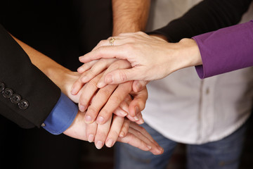group of employees hands together teamwork dedication