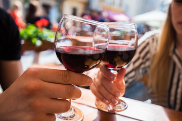 Young couple with glasses of red wine in a restaurant with city view