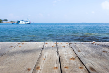 Close up with wooden walkway and view of sea and blue sky