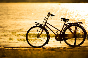 Fototapeta na wymiar bicycle silhouette at the sunset or sunrise
