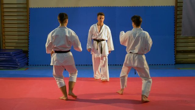 Young men performing self defense karate sequence demonstration at the dojo