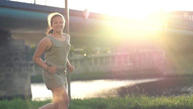 Happy girl running near river in city, super slow motion 240fps
