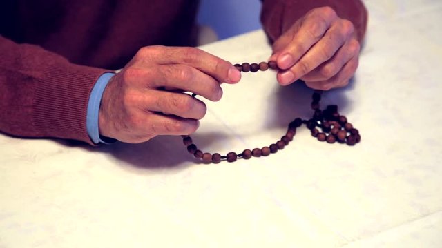 speeding up of male hands while praying with Rosary beads