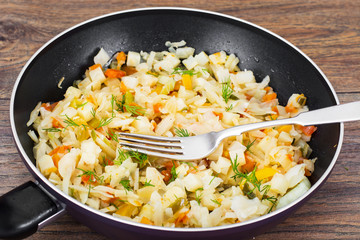 Stewed cabbage in frying pan with vegetables