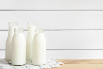 Milk bottle put on wooden table in white wood wall room.