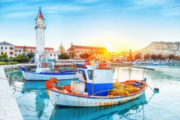 Gartenposter Zante - Zakinthos island, old port with moored boats and church tower landmark. Majestic sunset scenery, sun glowing visible. © Feel good studio