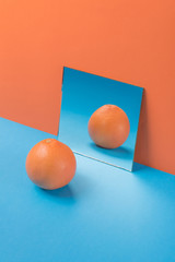 Grapefruit on blue table isolated over orange background