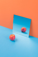 Apple on blue table isolated over orange background