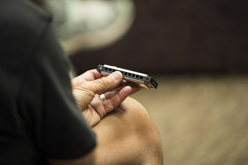 close up of a person holding a harmonica  - 158768911