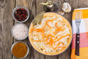Salted cabbage on plate on the background of wooden table