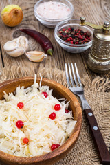 Salted cabbage on plate on the background of wooden table