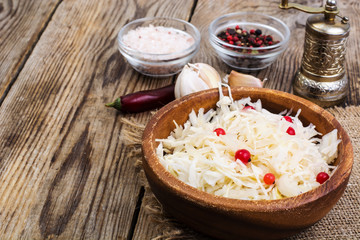 Salted cabbage on plate on the background of wooden table