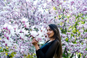 woman with long, brunette hair posing at magnolia tree