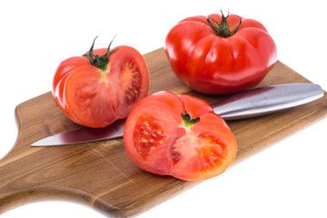 Red tomato on wooden board