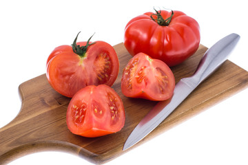 Red tomato on wooden board