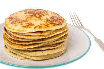 Stack of fried vanilla pancakes on plate on white background